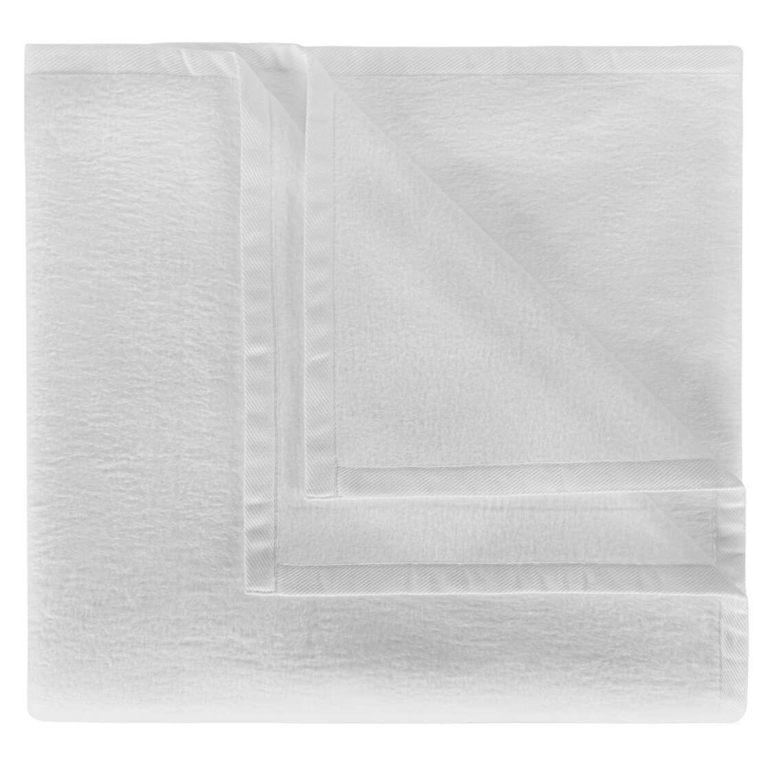 White BOVI Finnley blanket draped over a beige chair on a carpeted floor