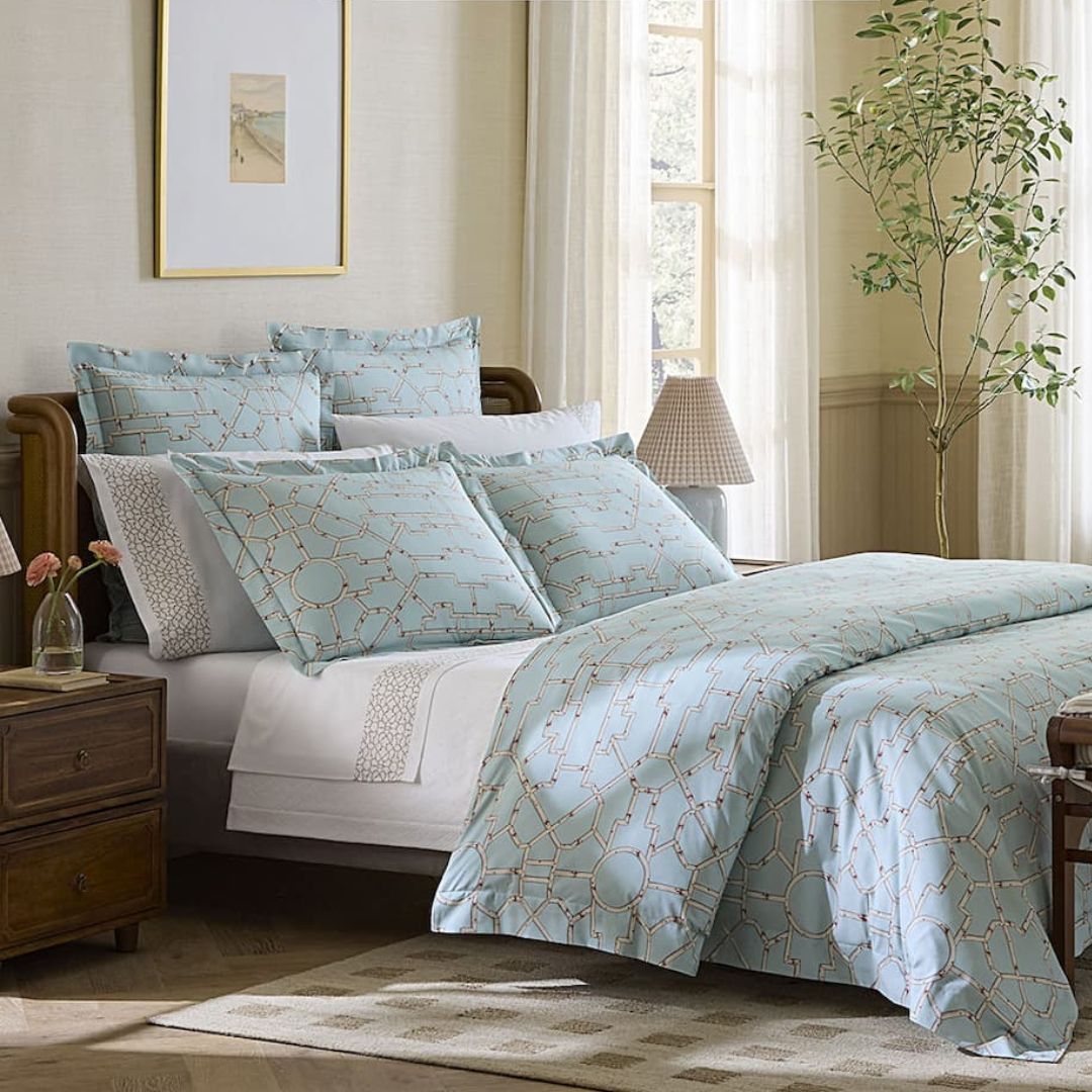 Bedroom with light blue patterned bedding and pillows