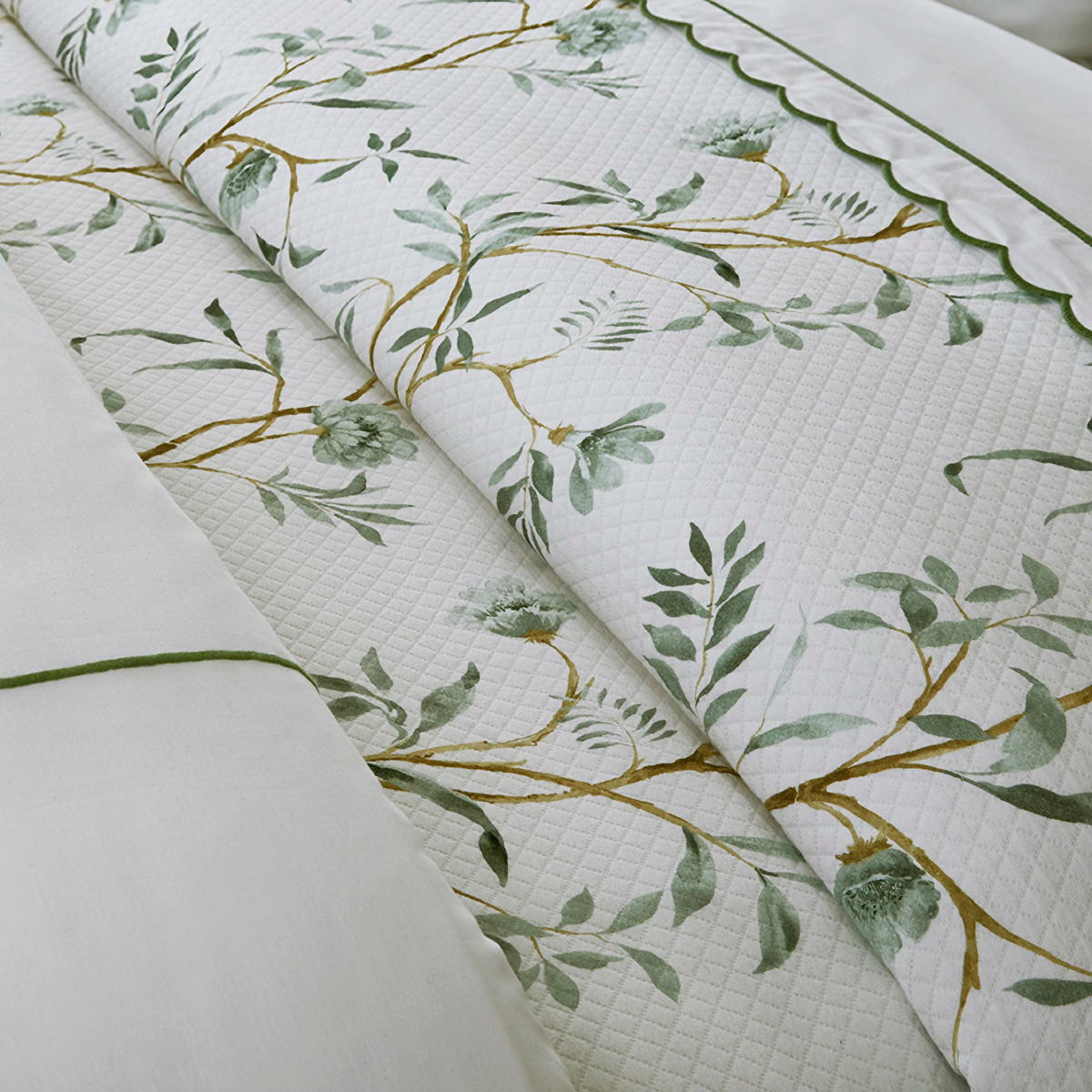 Closeup of Downtown Company Mae Coverlet and Shams with green Floral design