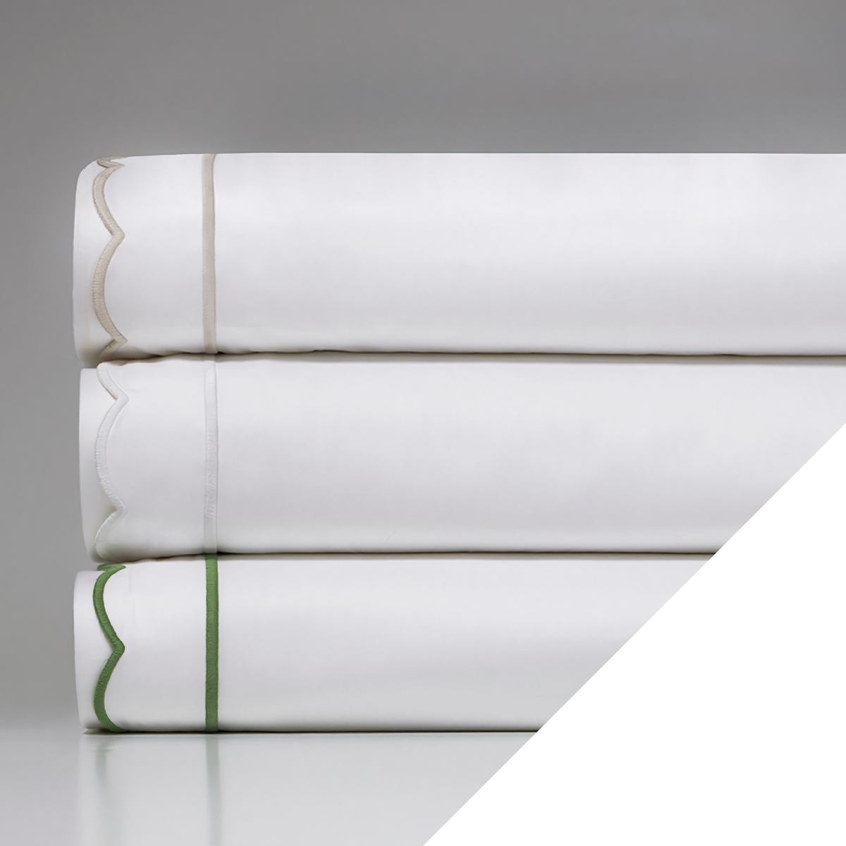 A stack of Downtown Company Scallop Bedding with White swatch
