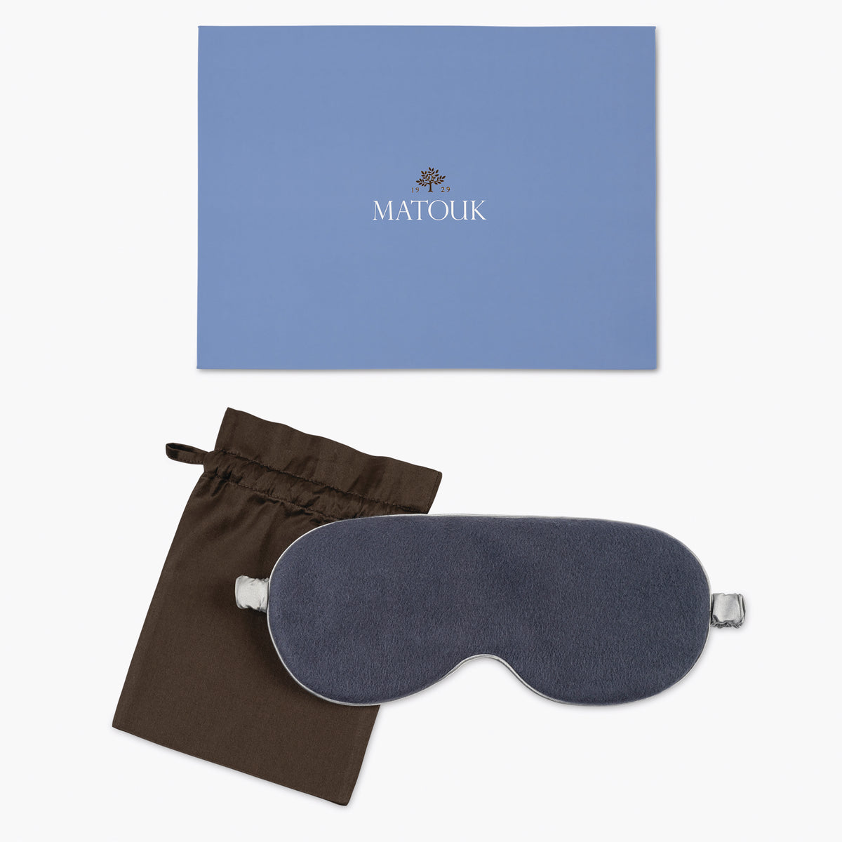 Blue sleep mask with brown pouch and blue Matouk branded box on a white background