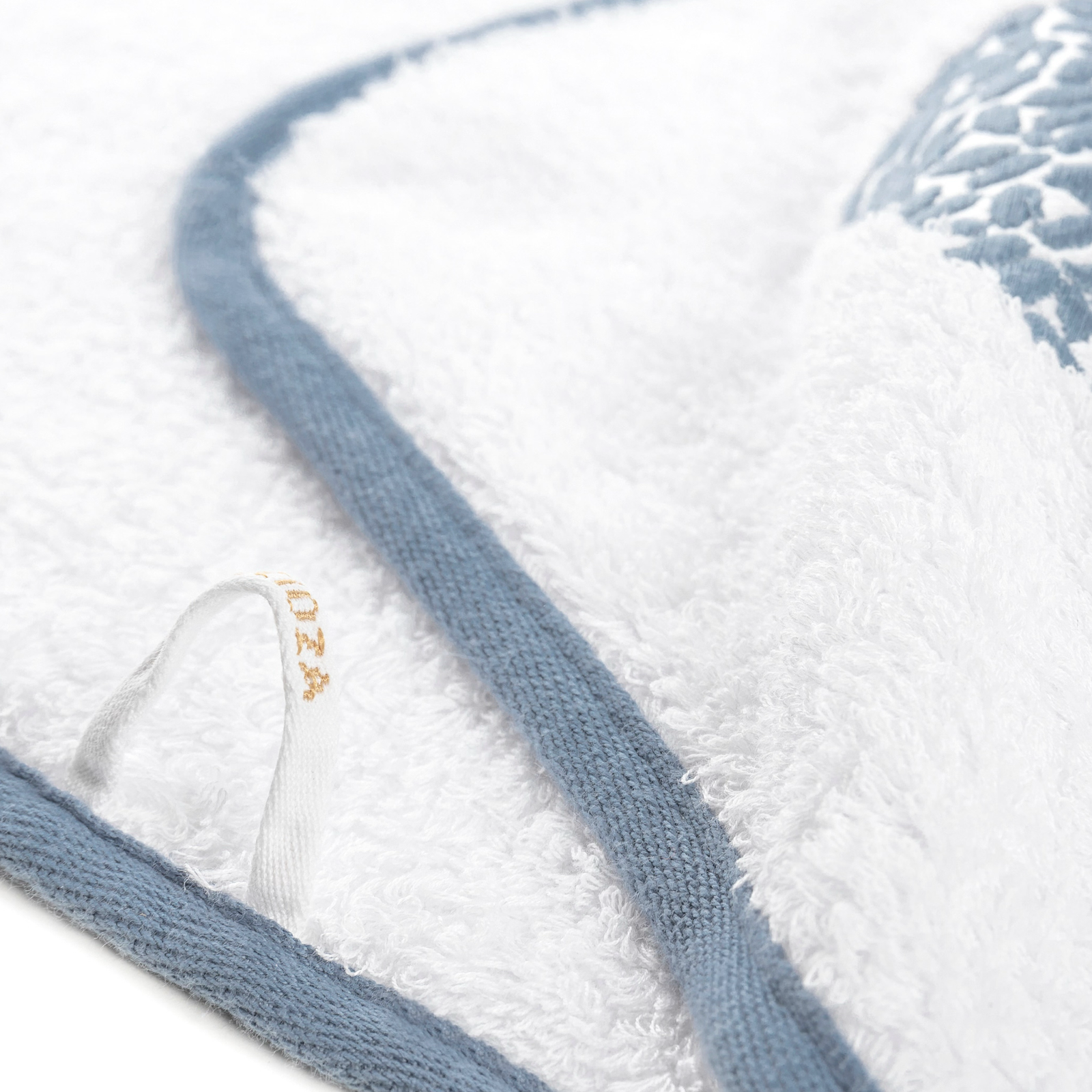 Graccioza Malone Bath Towel in White and French Blue hanging on a stool