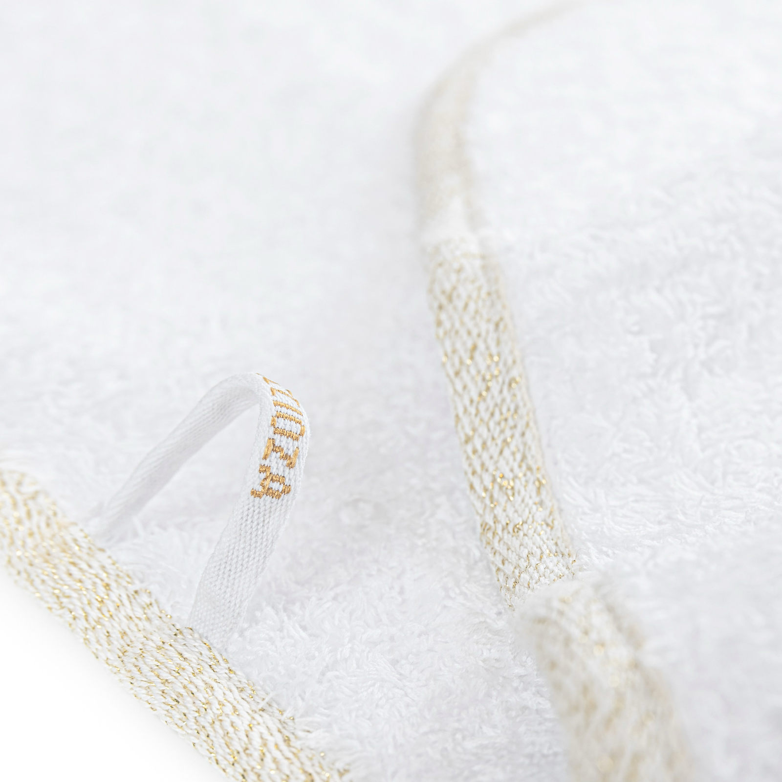 Stack of Graccioza Parson Bath Towels in White and Gold