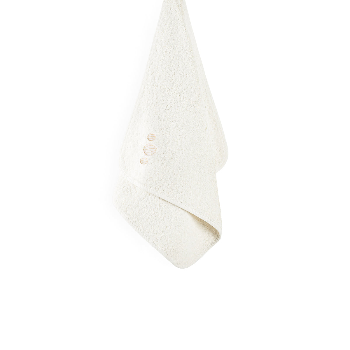 Cream-colored Graccioza Enchant bath towel hanging with small embroidered shell icons.