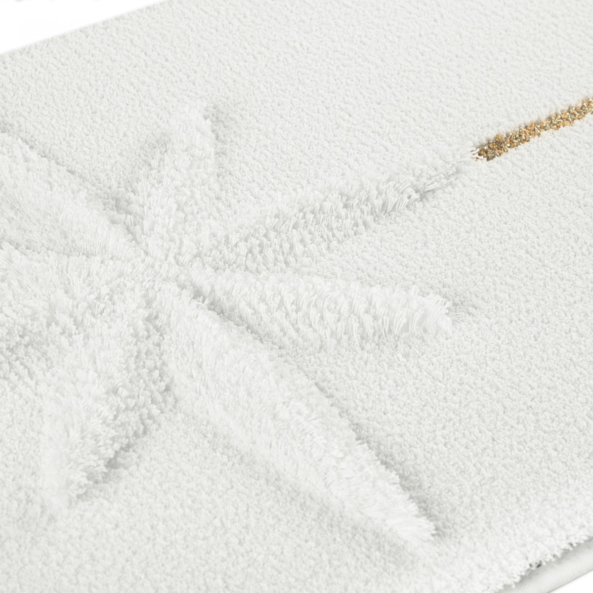 White Egyptian cotton bath mat with a textured star design and a thin metallic gold accent line.