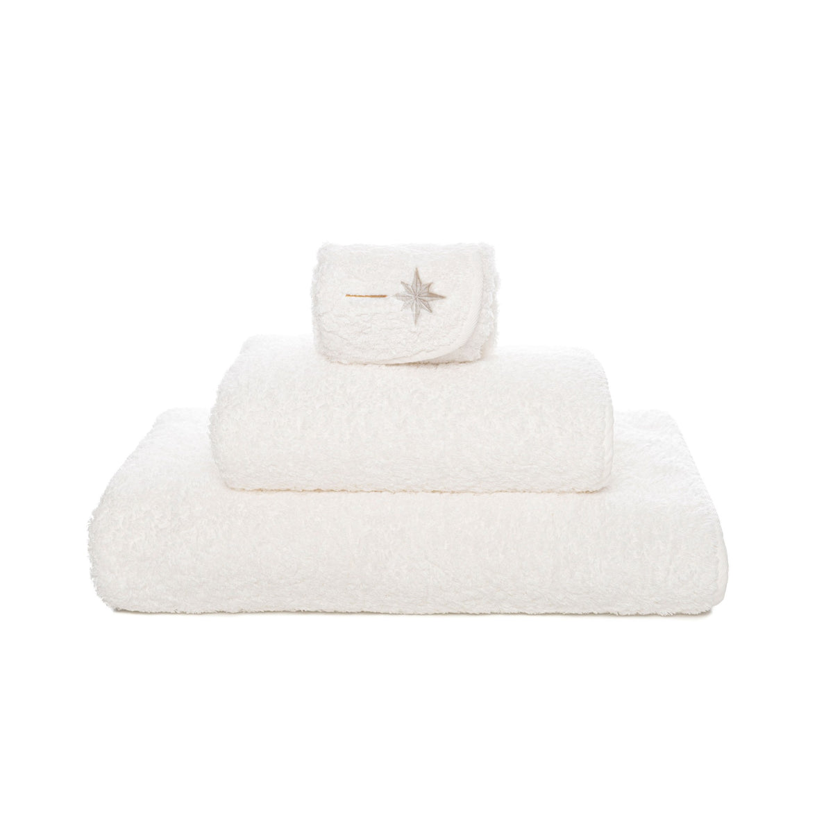 A stack of three white Graccioza Sparkle bath towels, with the top folded towel featuring an embroidered star design.