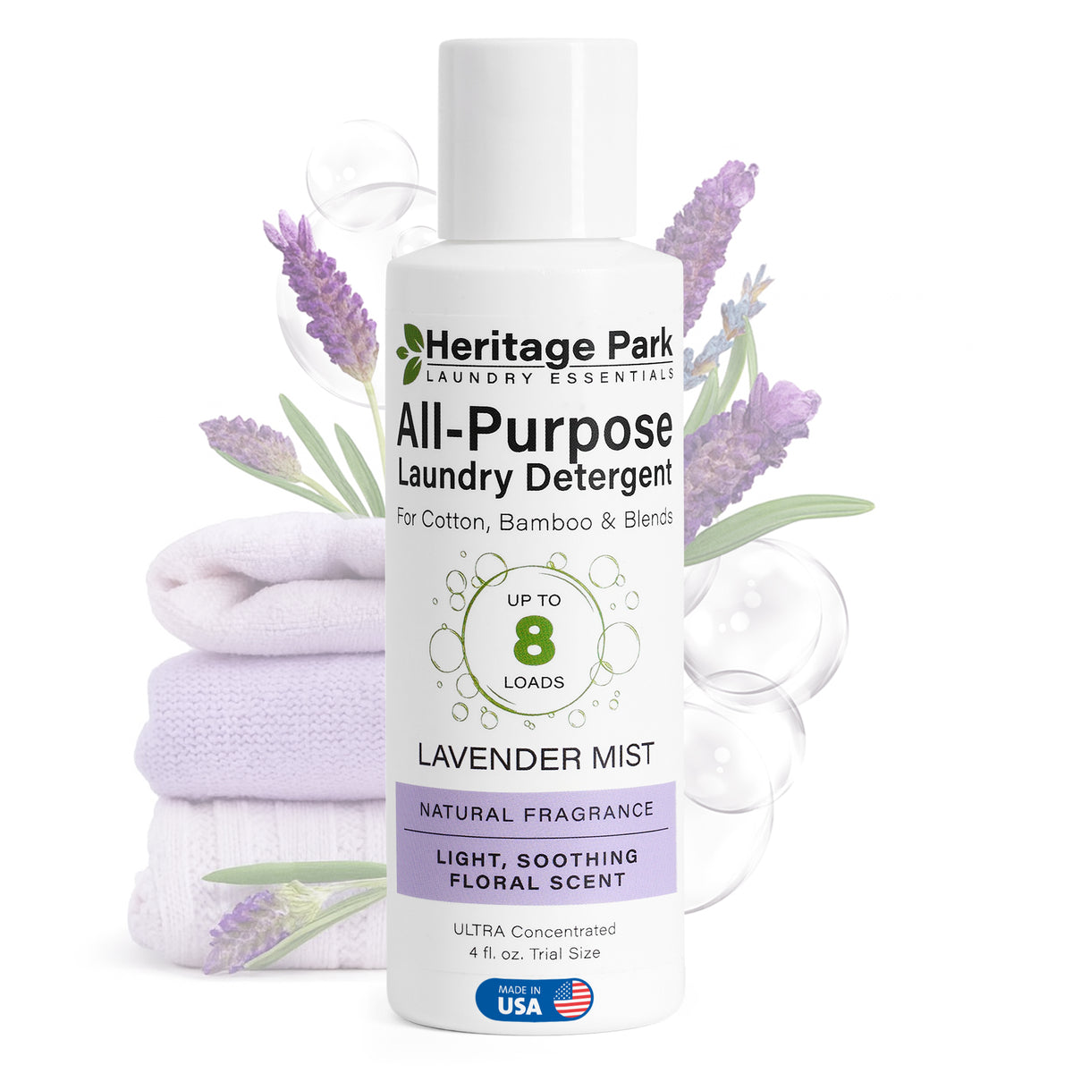 A bottle of luxury, biodegradable laundry detergent in Lavender Mist scent sits before neatly folded towels.