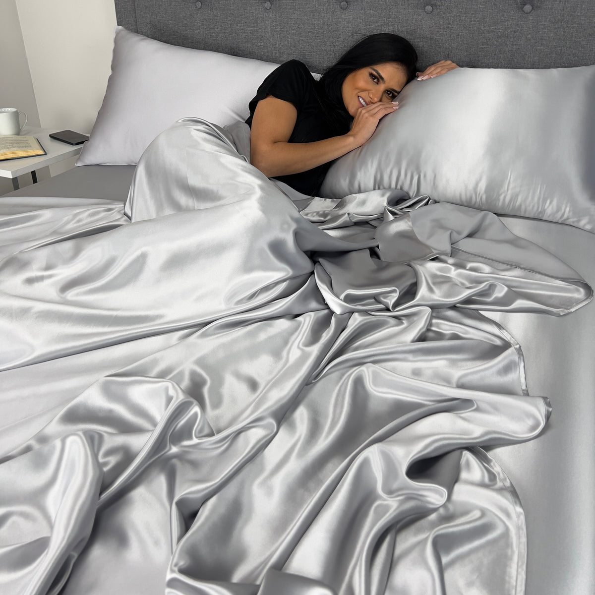 Woman waking up in bed with soft sage sheet and sage pillowcase, feeling refreshed