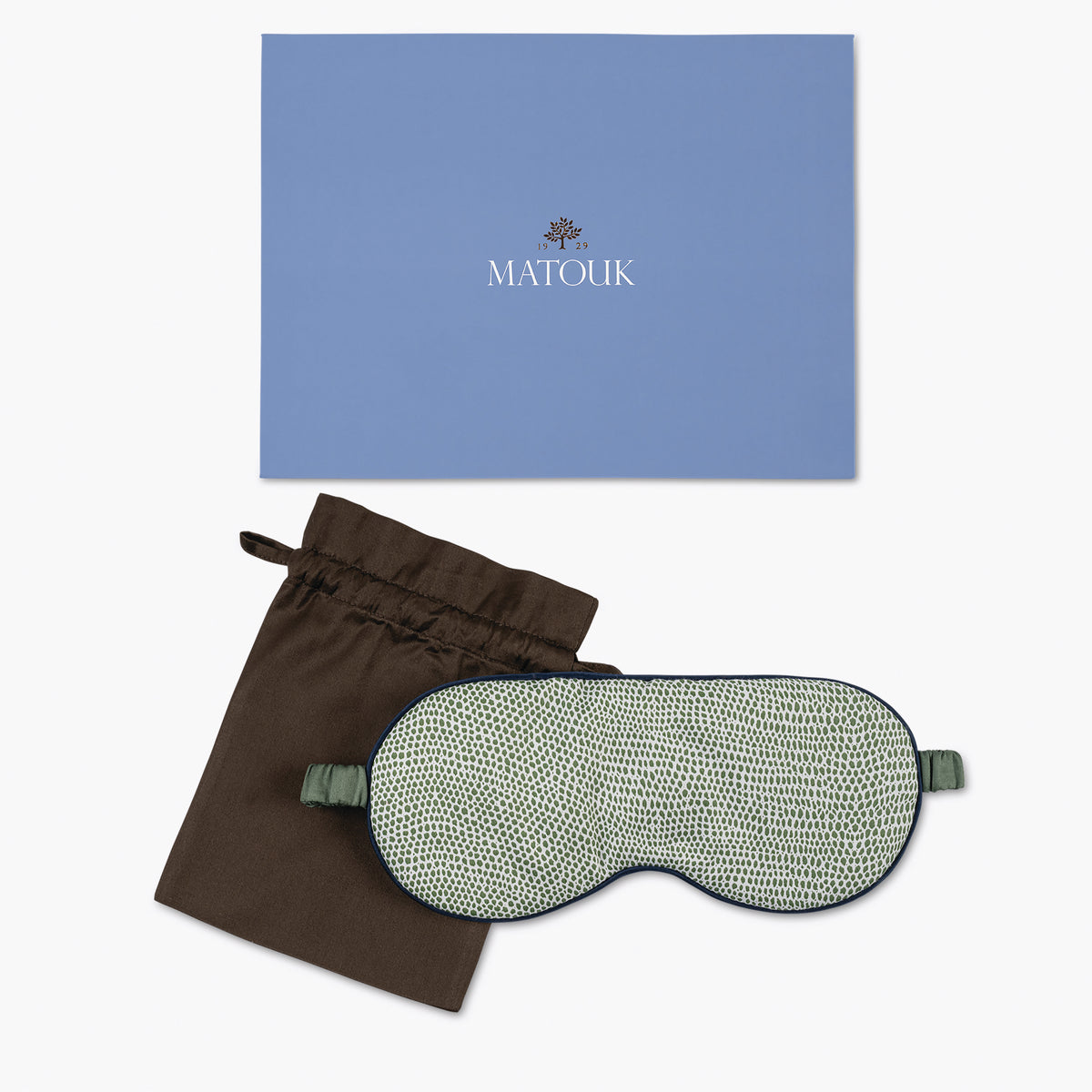 Green sleep mask with brown pouch and blue Matouk branded box on a white background