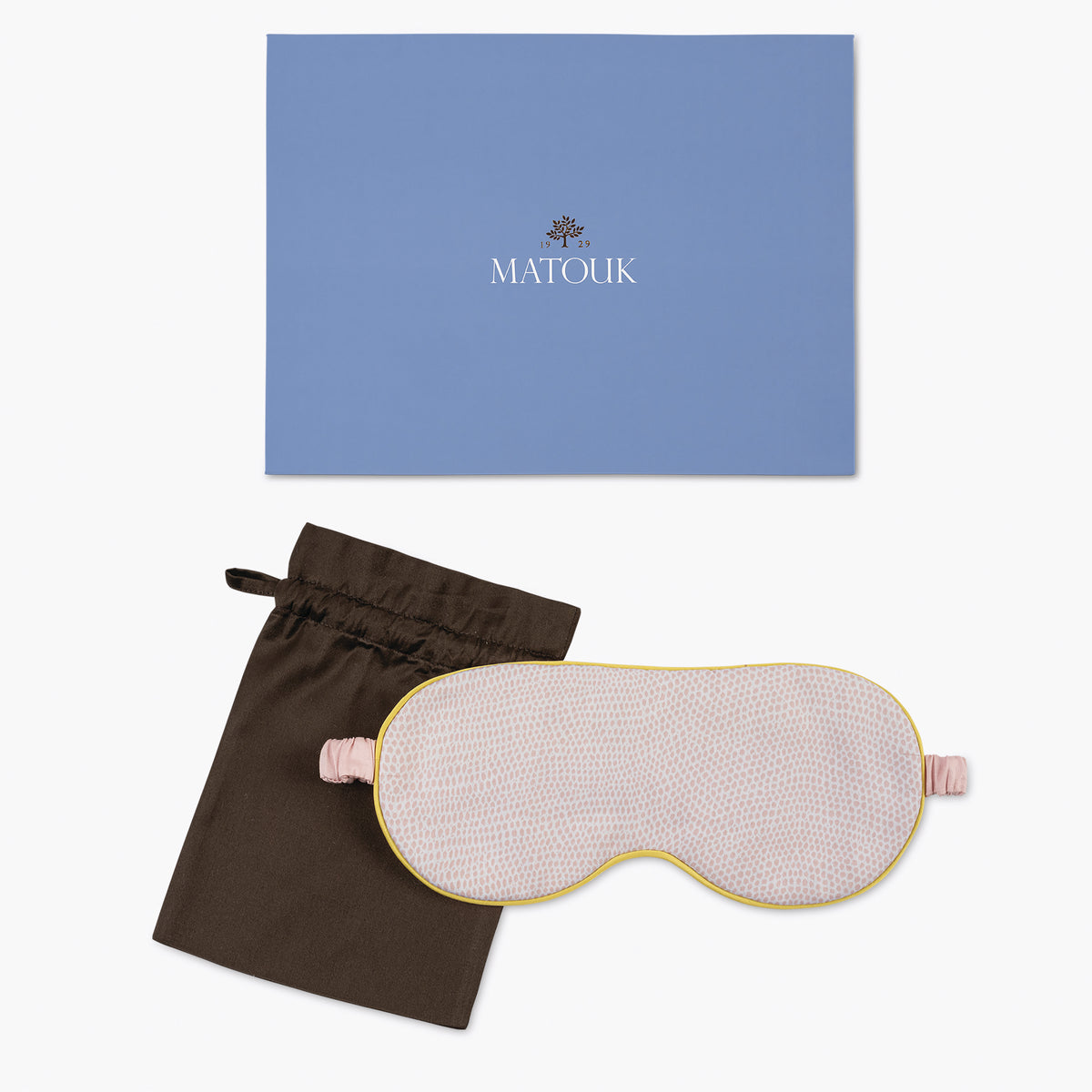 Sleep mask with brown pouch and blue Matouk branded box on a white background