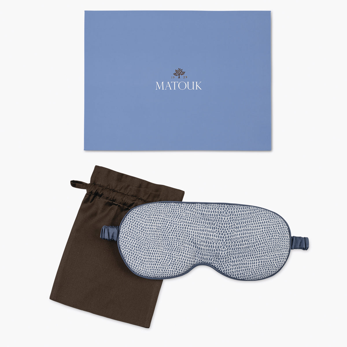 Sleep mask with blue packaging and black drawstring bag on a white background