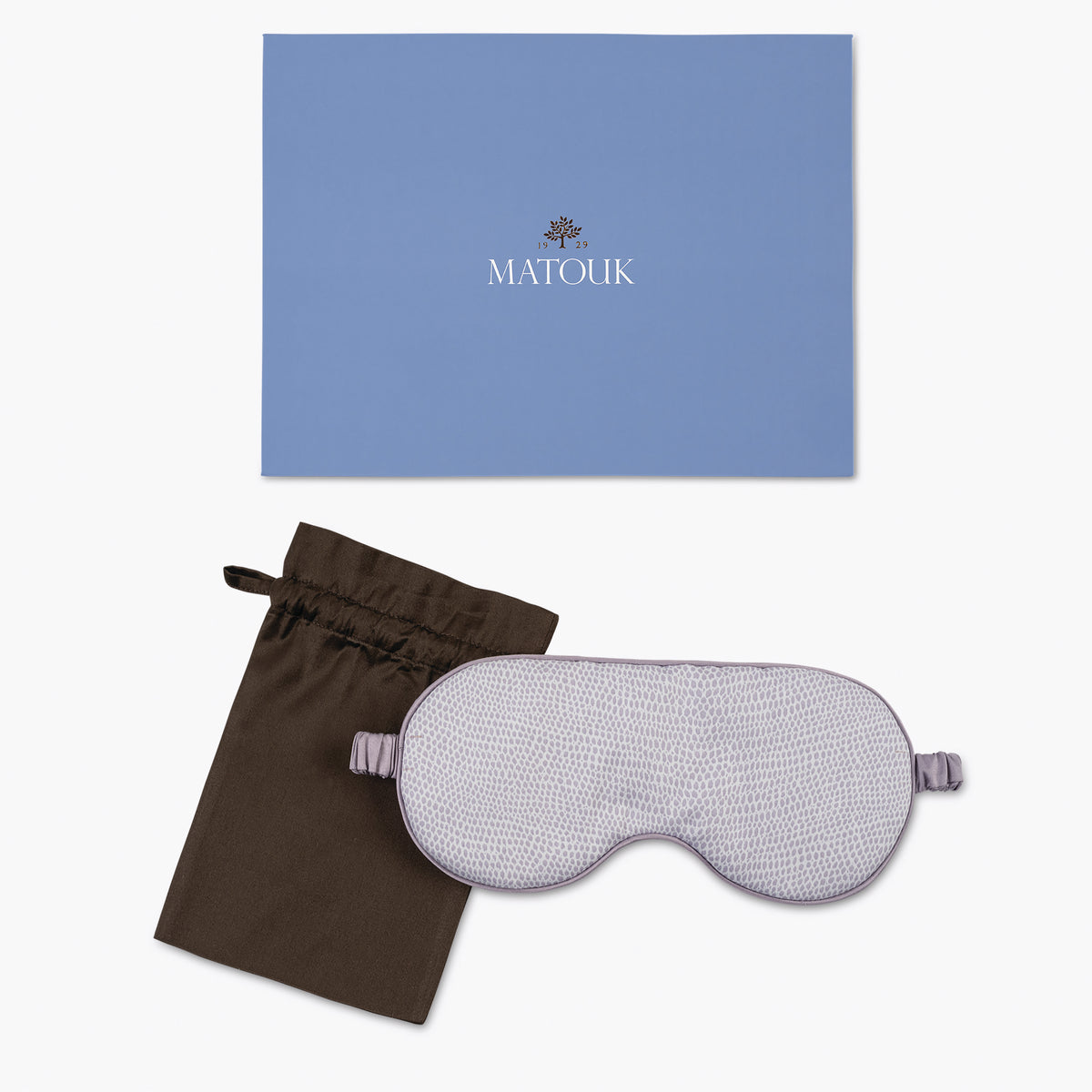 Sleep mask with brown drawstring bag and blue Matouk branded box on a white background