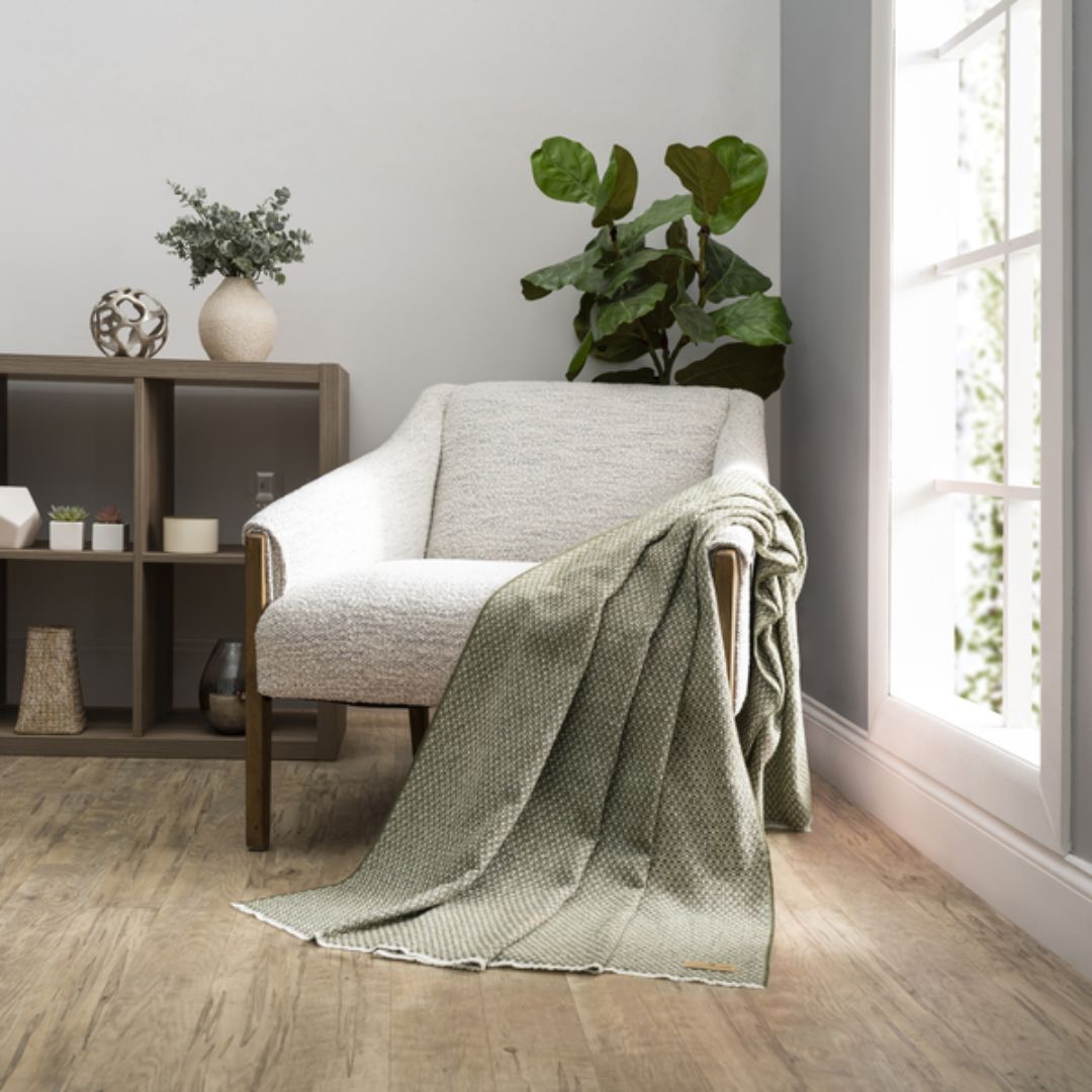 Cozy living room with a gray armchair draped with a Lands Downunder Hudson Valley Throw in Chive color
