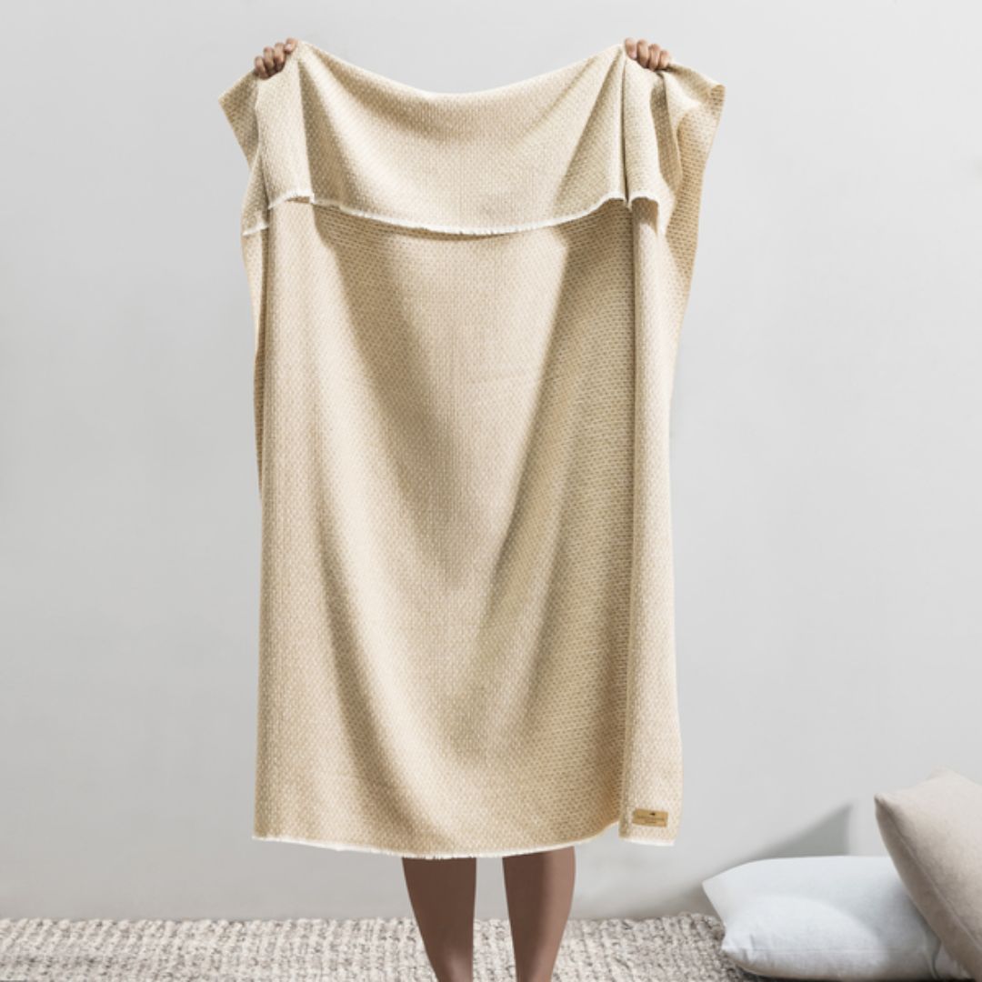 Person holding up a Lands Downunder Hudson Valley Throw in Dune color