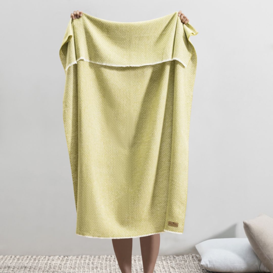 Person holding up a Lands Downunder Hudson Valley Throw in Lemongrass color