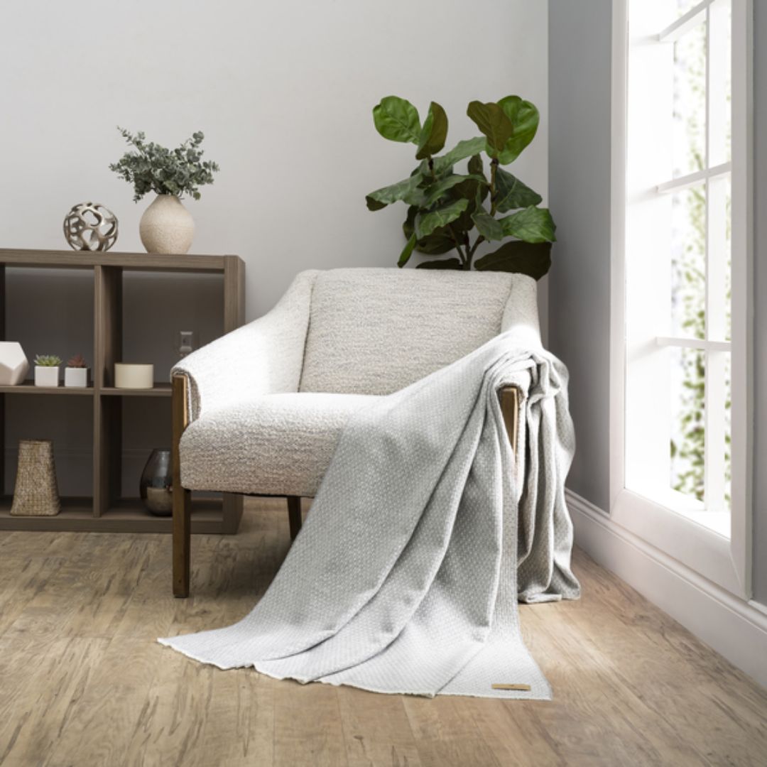 Cozy living room with a gray armchair draped with a Lands Downunder Hudson Valley Throw in Light Gray color
