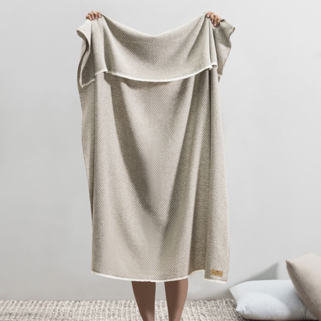Person holding up a Lands Downunder Hudson Valley Throw in Mink color