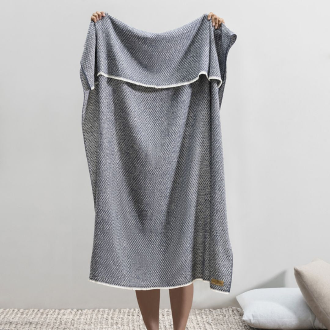 Person holding up a Lands Downunder Hudson Valley Throw in Navy color