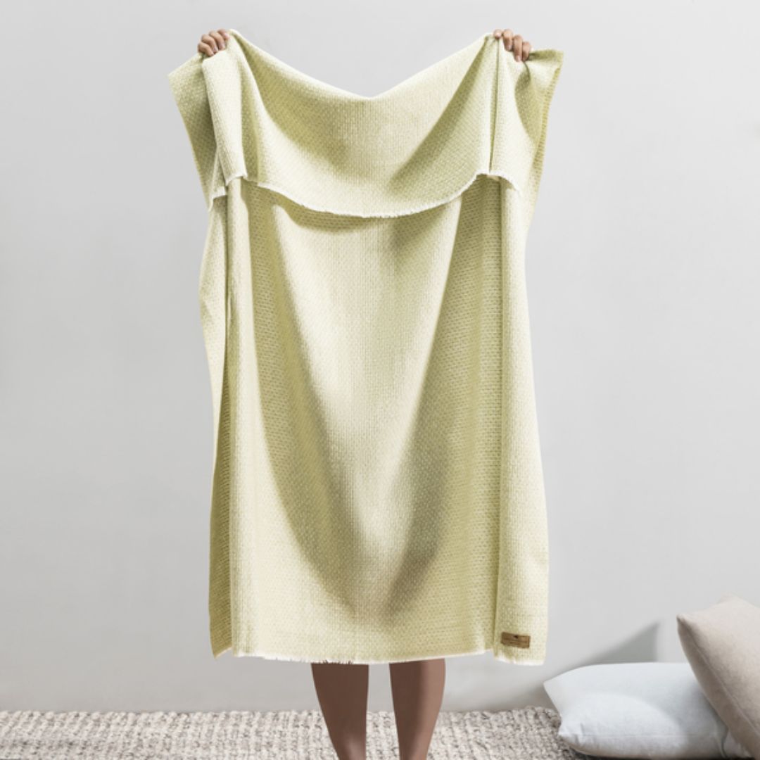 Person holding up a Lands Downunder Hudson Valley Throw in White Sage color