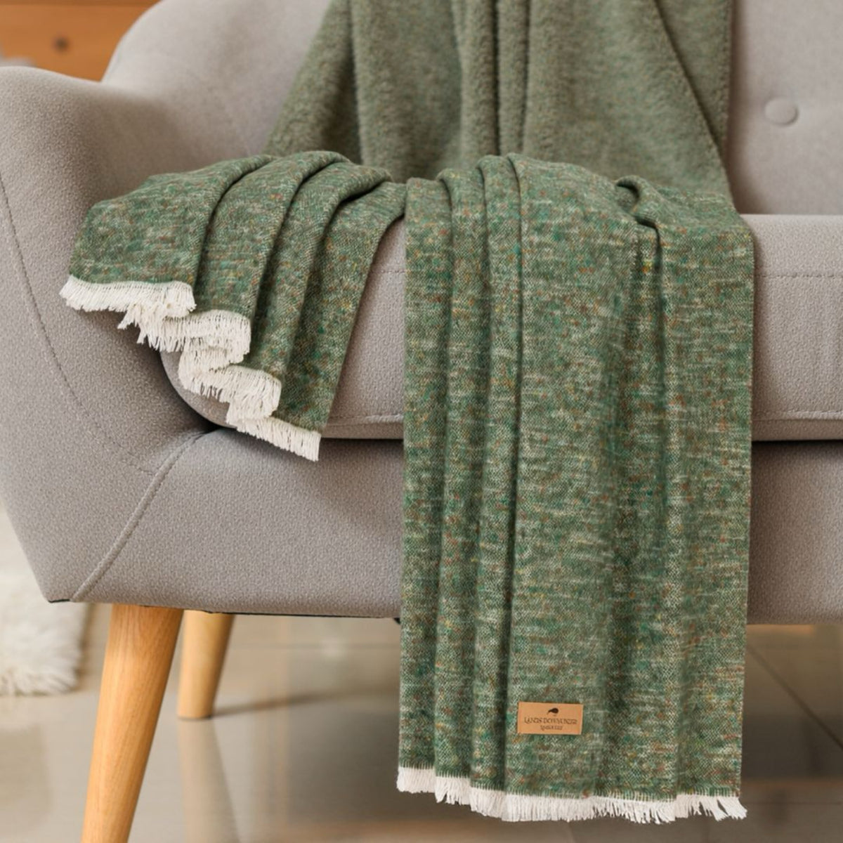 Olive colored Lands Downunder Cinder Mist Throw on a chair