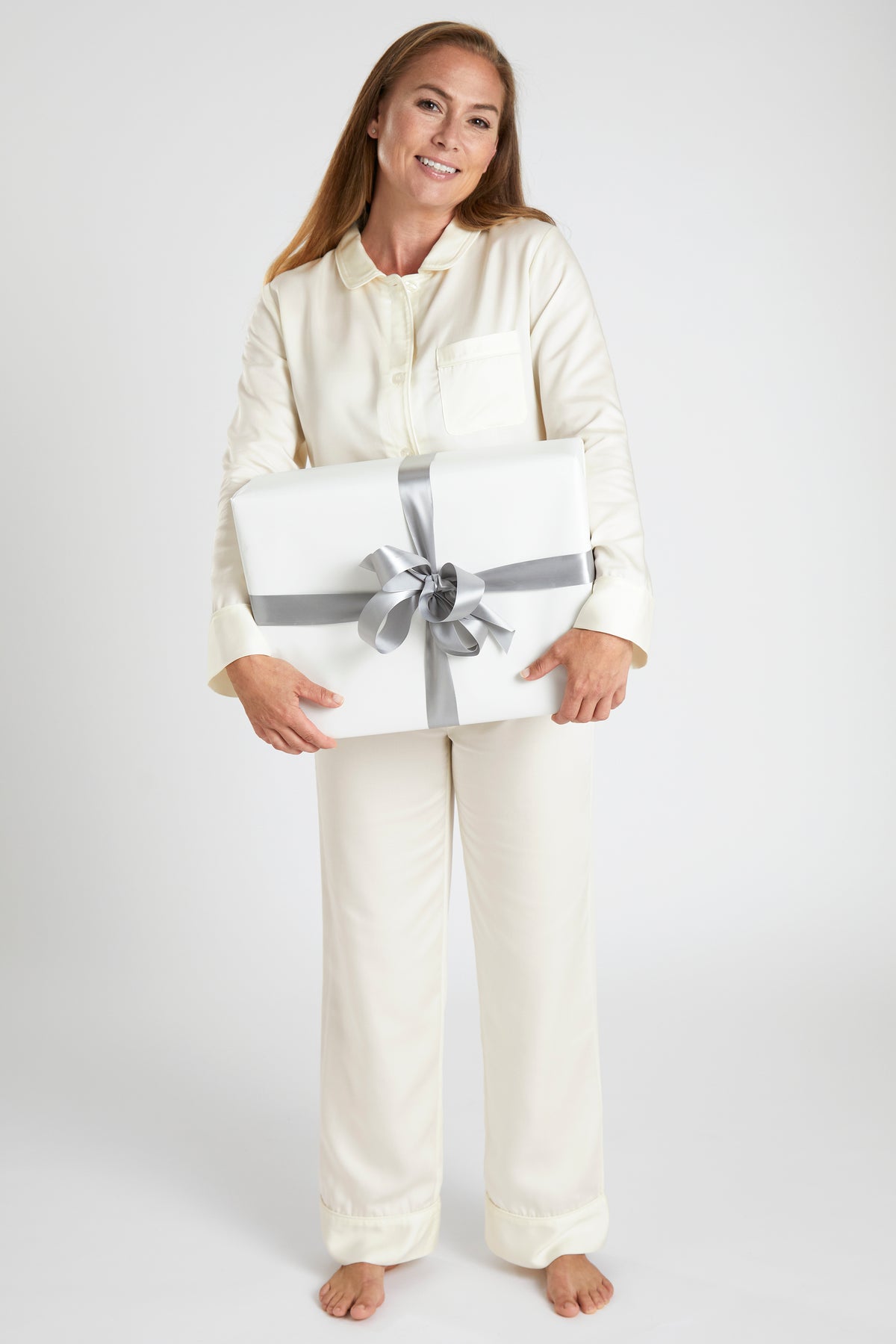 Model Holding a Gift Wearing Ivory Color Pine Cone Hill Silken Solid Pajama