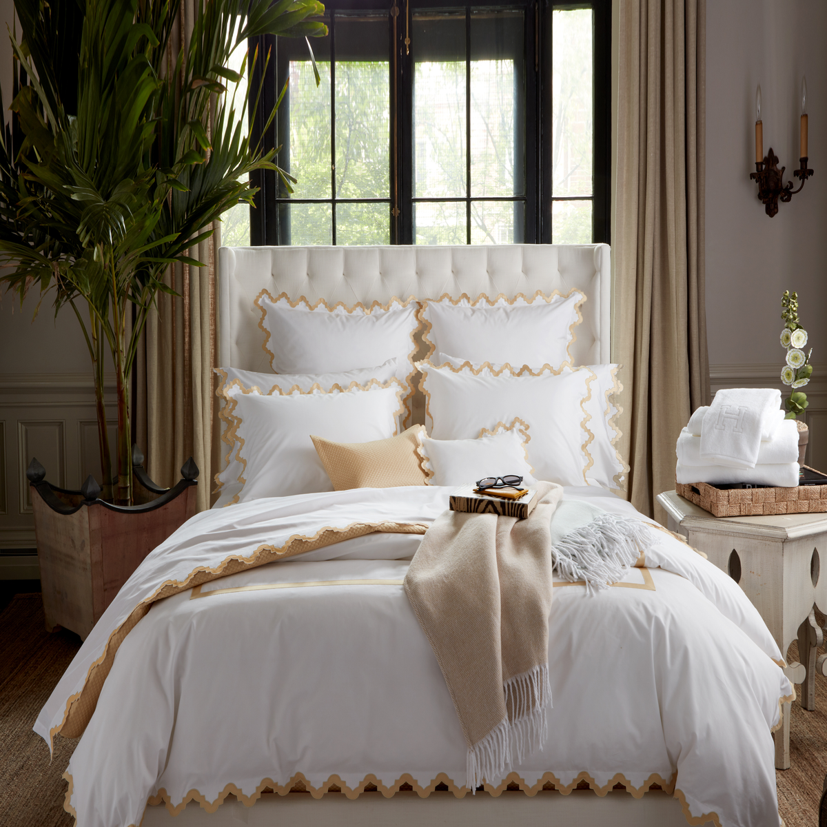 Lifestyle Image of a Full Bed Dressed in Matouk Aziza Bedding in Champagne Color