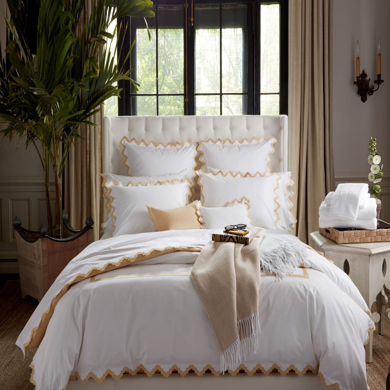 Lifestyle Image of a Full Bed Dressed in Matouk Aziza Bedding in Champagne Color