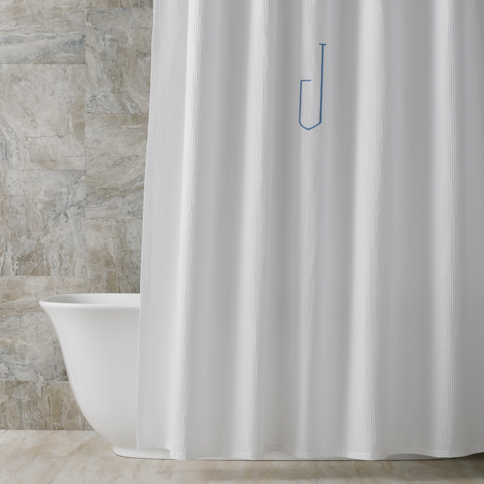 Bath Tub Behind a White Matouk Belgian Waffle Shower Curtain