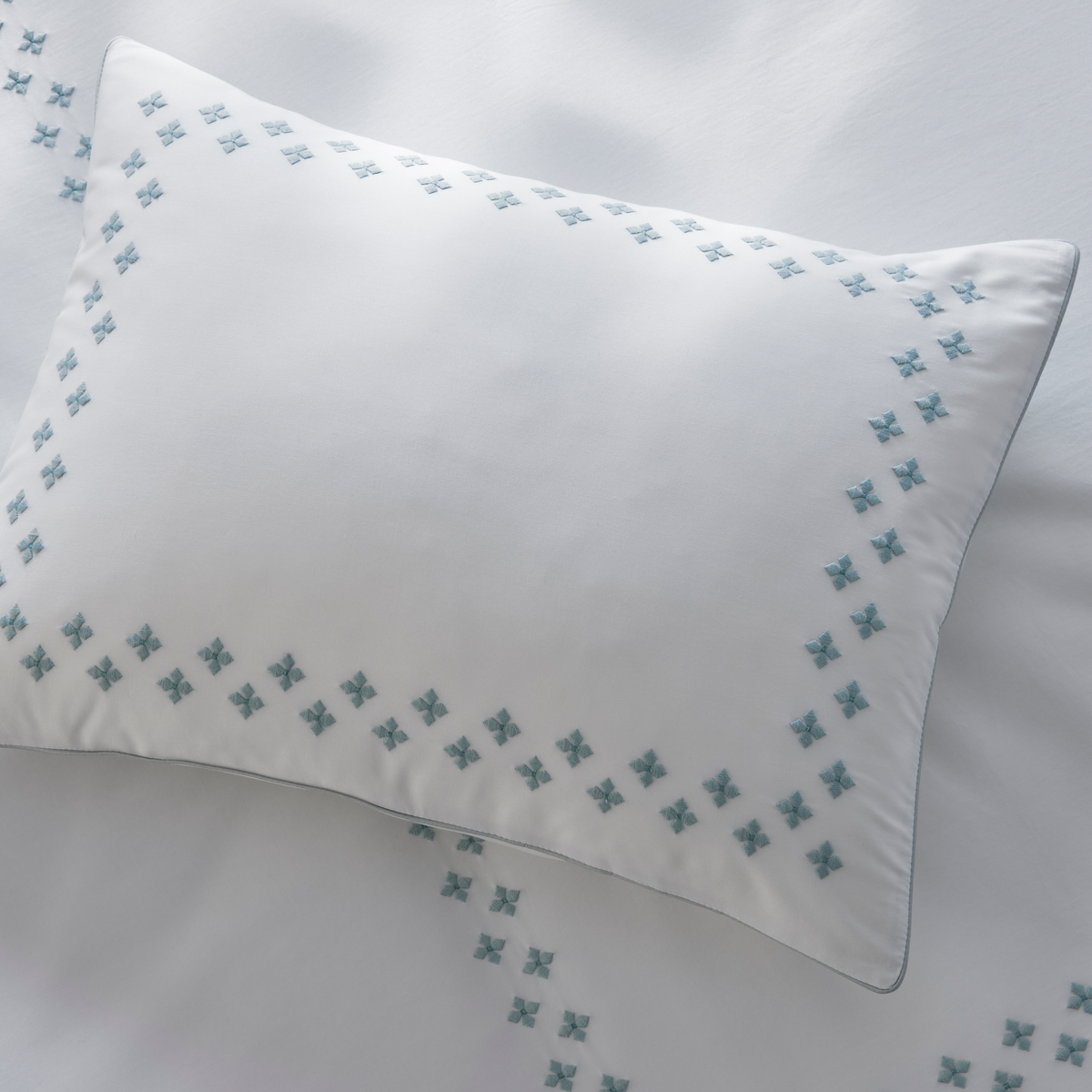 Closeup of Matouk Casablanca Embroidery on a sham and a sheet