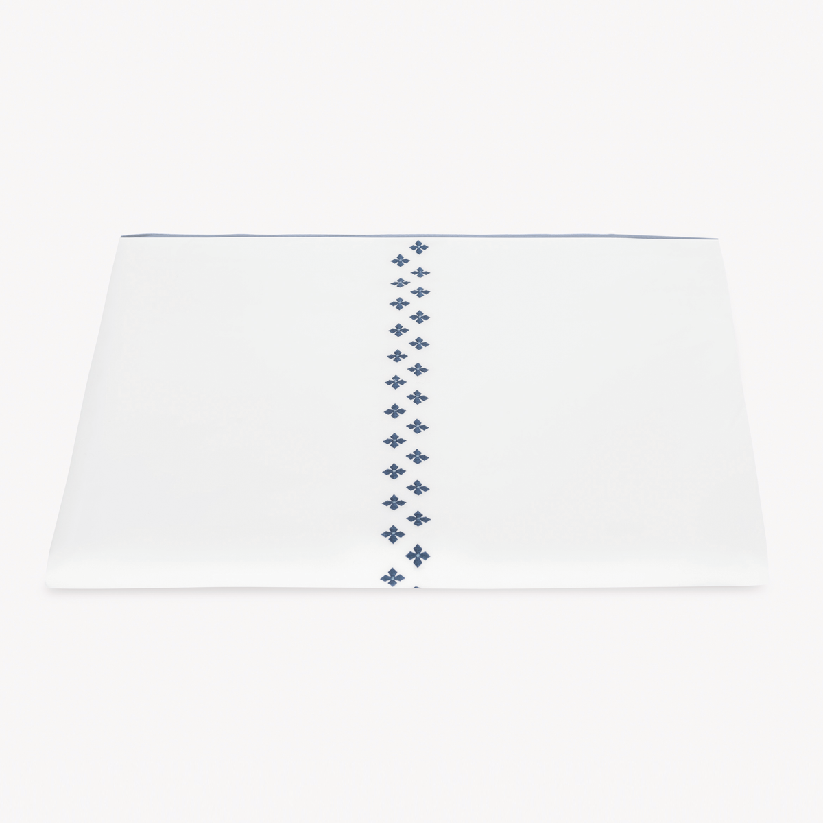 A folded white Egyptian cotton percale Duvet Cover featuring Matouk Casablanca Embroidery in Indigo color