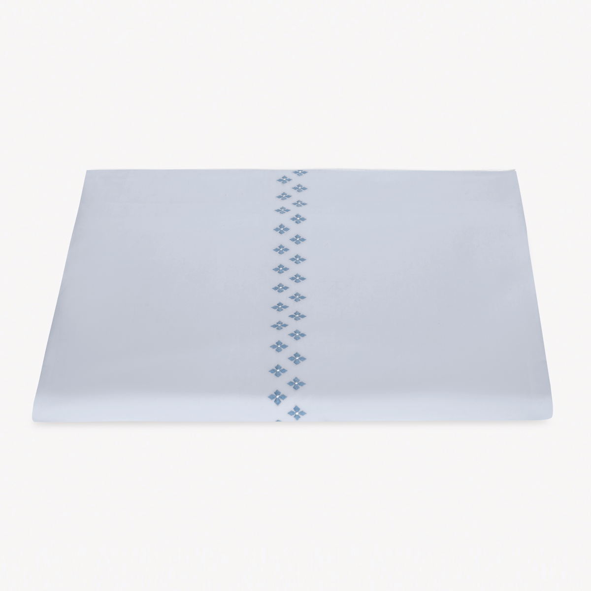 A folded white Egyptian cotton percale Duvet Cover featuring Matouk Casablanca Embroidery in Sky Blue color.