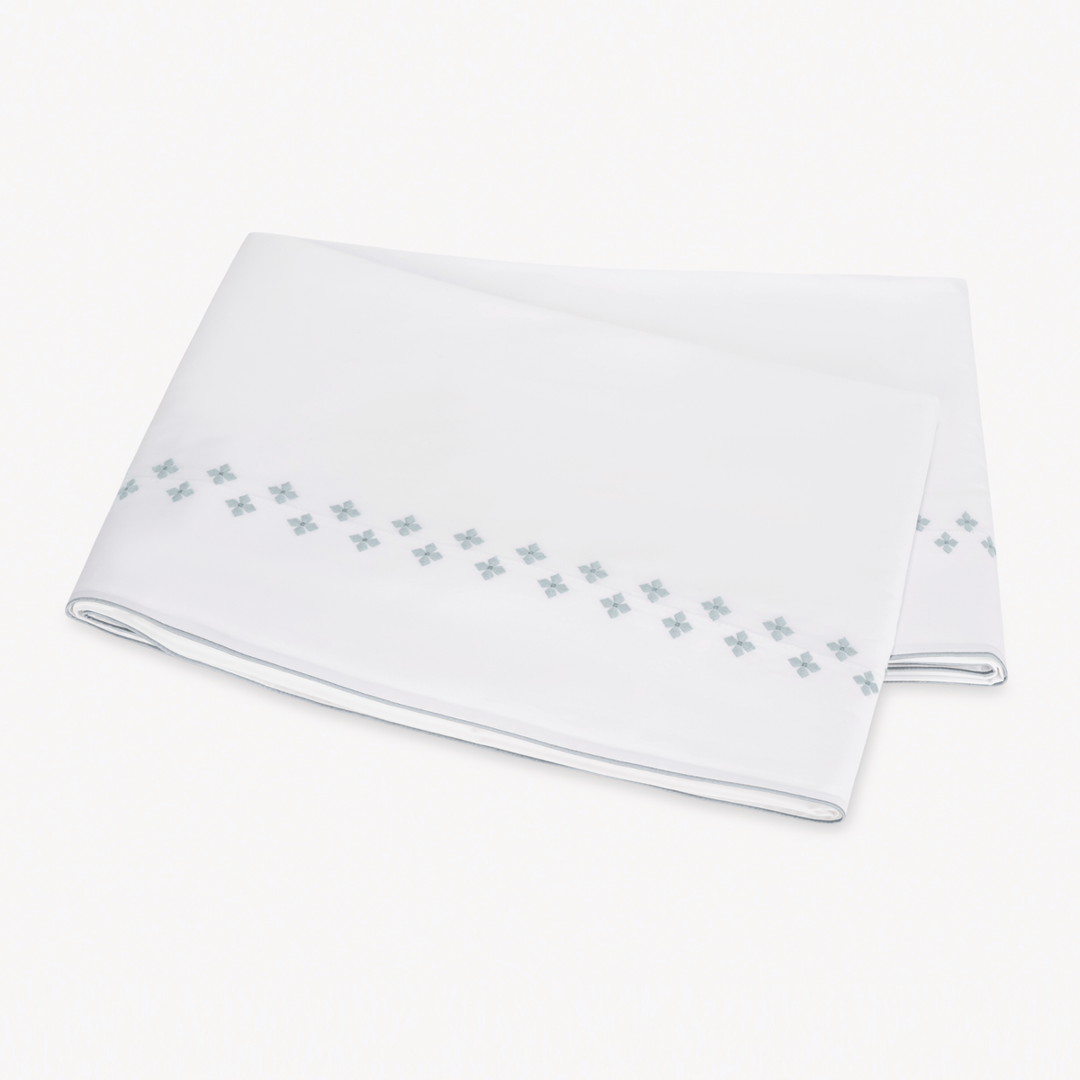 Folded white Flat Sheet in Egyptian cotton percale with Matouk Casablanca Embroidery in Pool color