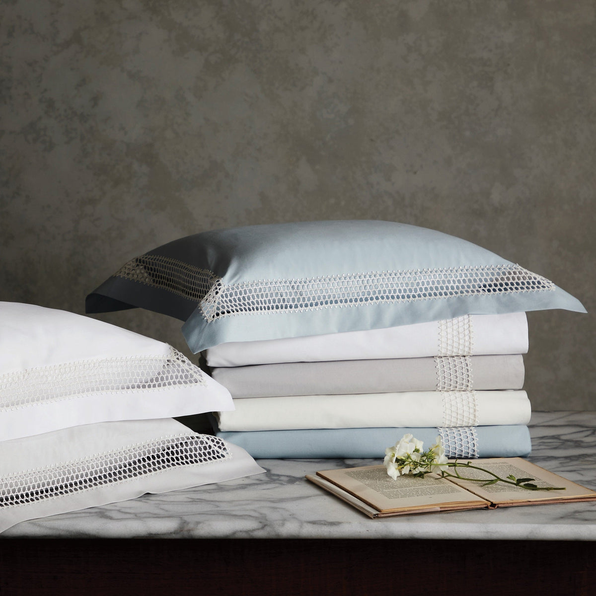 Stack of Matouk Cecily Bedding with Different Colors