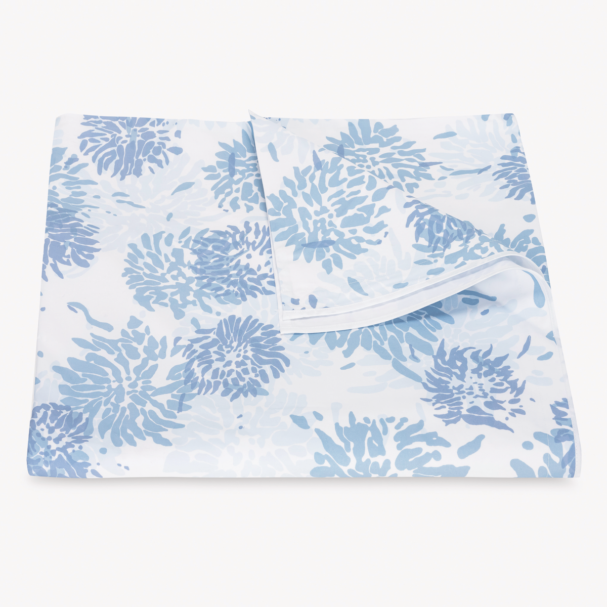 Folded Duvet Cover with blue floral-patterned Matouk Chrysanthemum bedding, with one corner lifted to show the underside