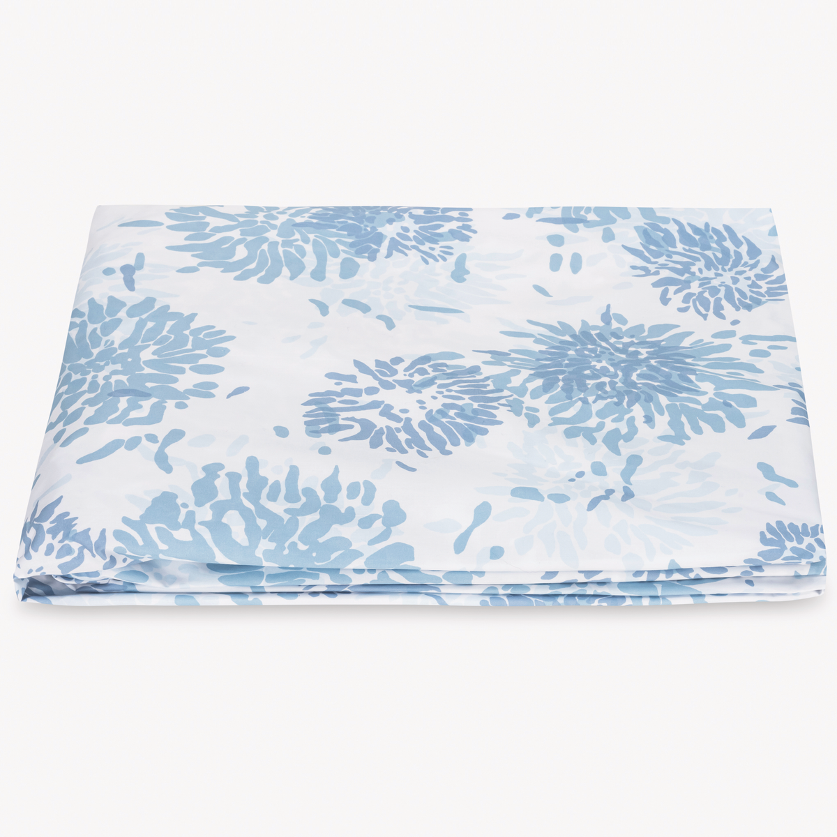 A folded fitted sheet in Egyptian cotton percale with blue floral pattern from Matouk Chrysanthemum Collection