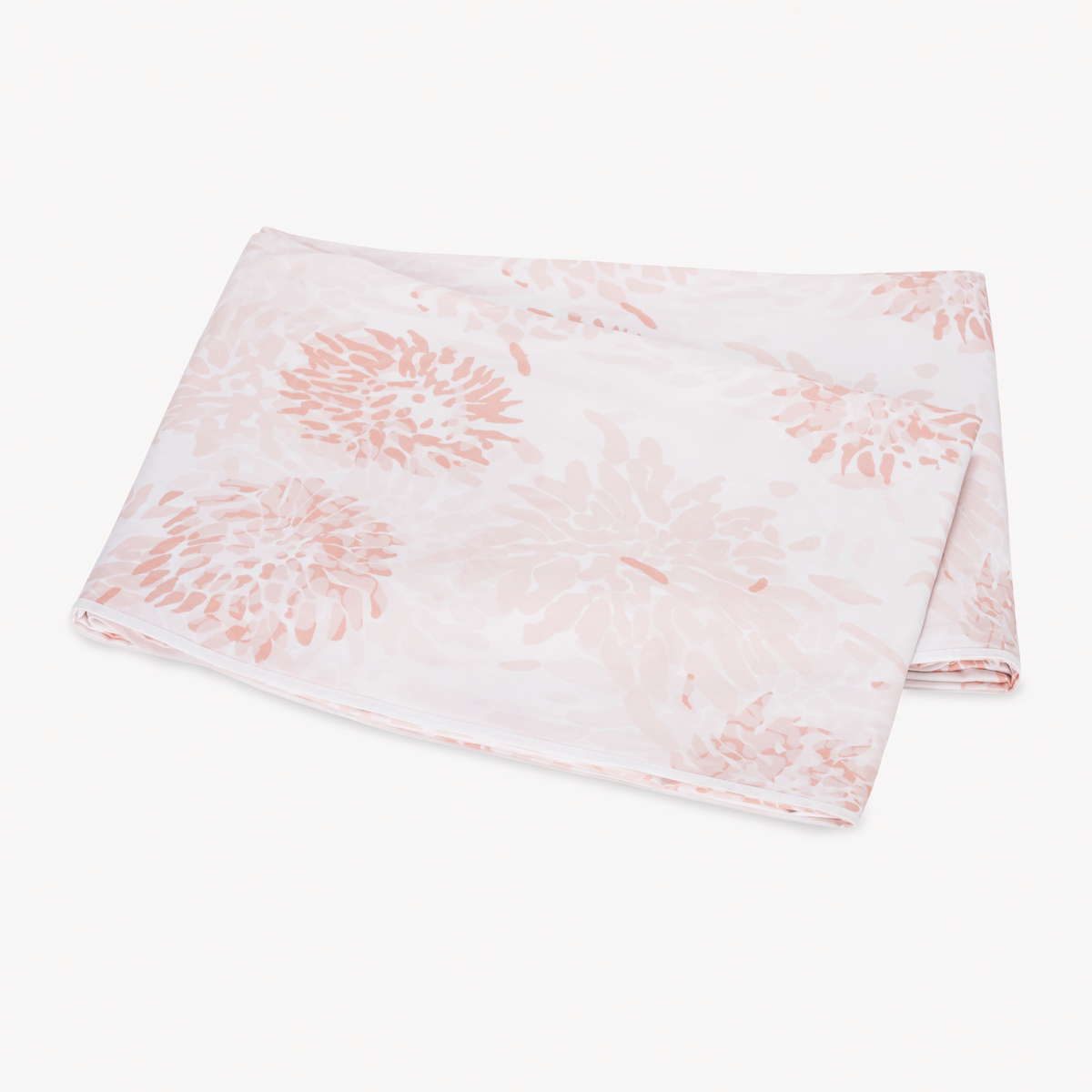A folded flat sheet with a blush floral pattern from Matouk Chrysanthemum bedding