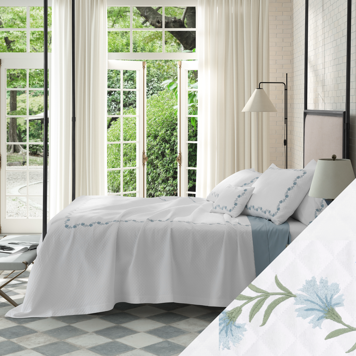 Bed in Matouk Daphne Matelasse Bedding with Bluebell design and a view of greenery outside
