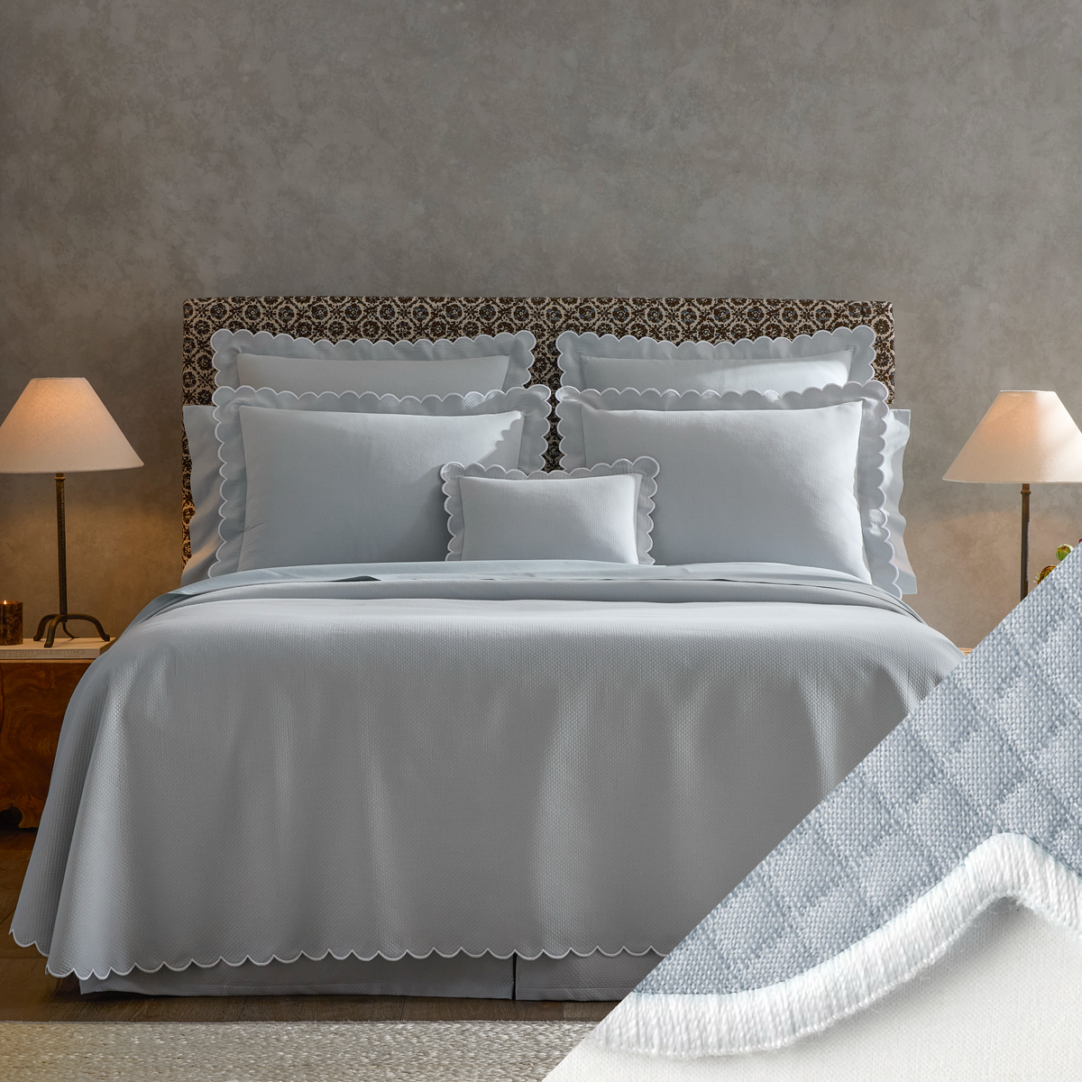 A neatly made bed with luxury bedding, two bedside lamps, and a close-up of Diamond Pique Bedding fabric in the corner.