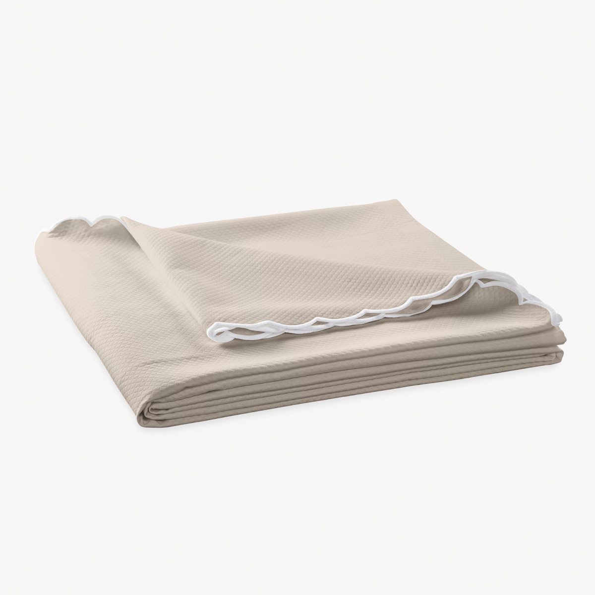 Folded Coverlet of Matouk Diamond Pique Bedding in Dune color