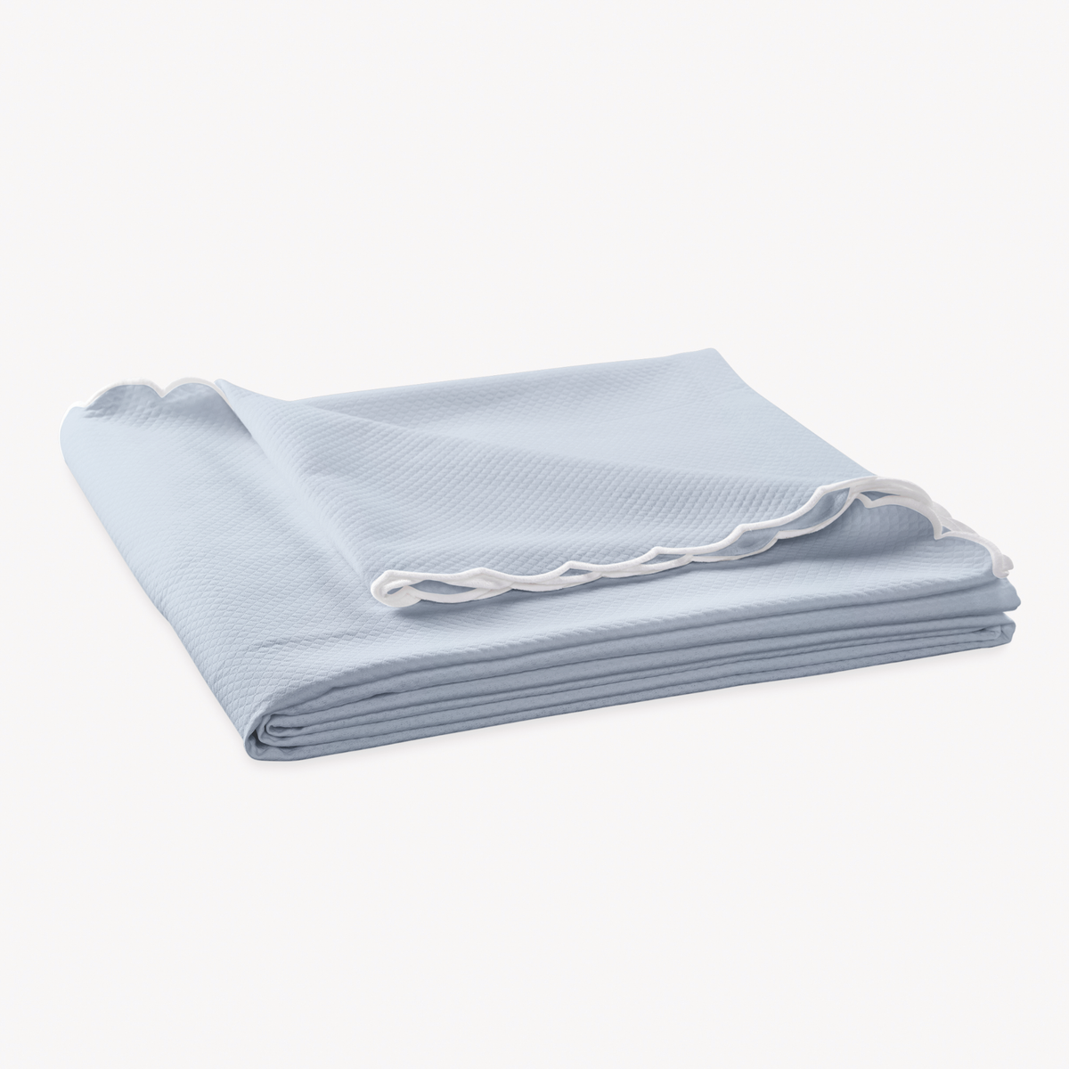 Folded Coverlet of Matouk Diamond Pique Bedding in Light blue color