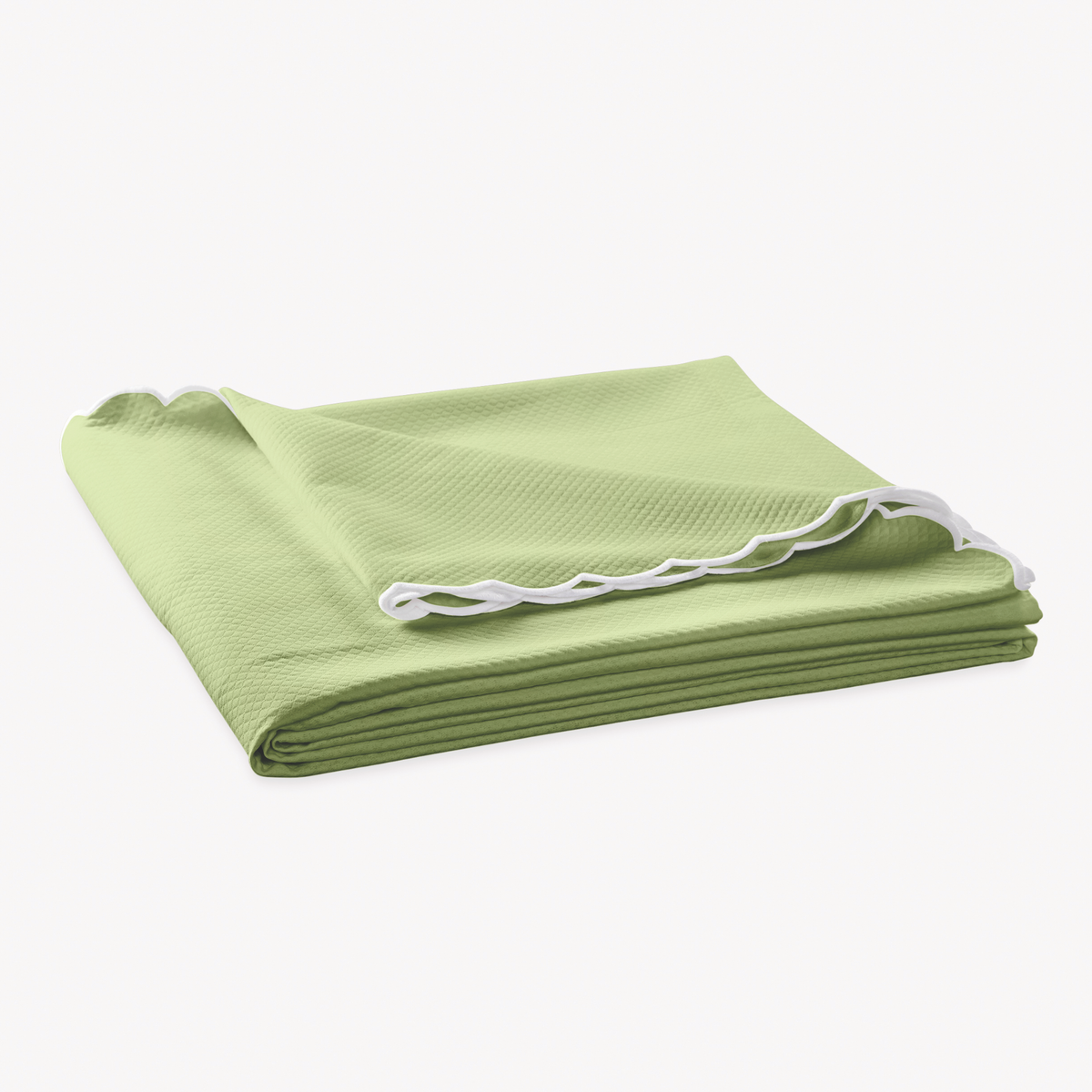 Folded Coverlet of Matouk Diamond Pique Bedding in Spring green color