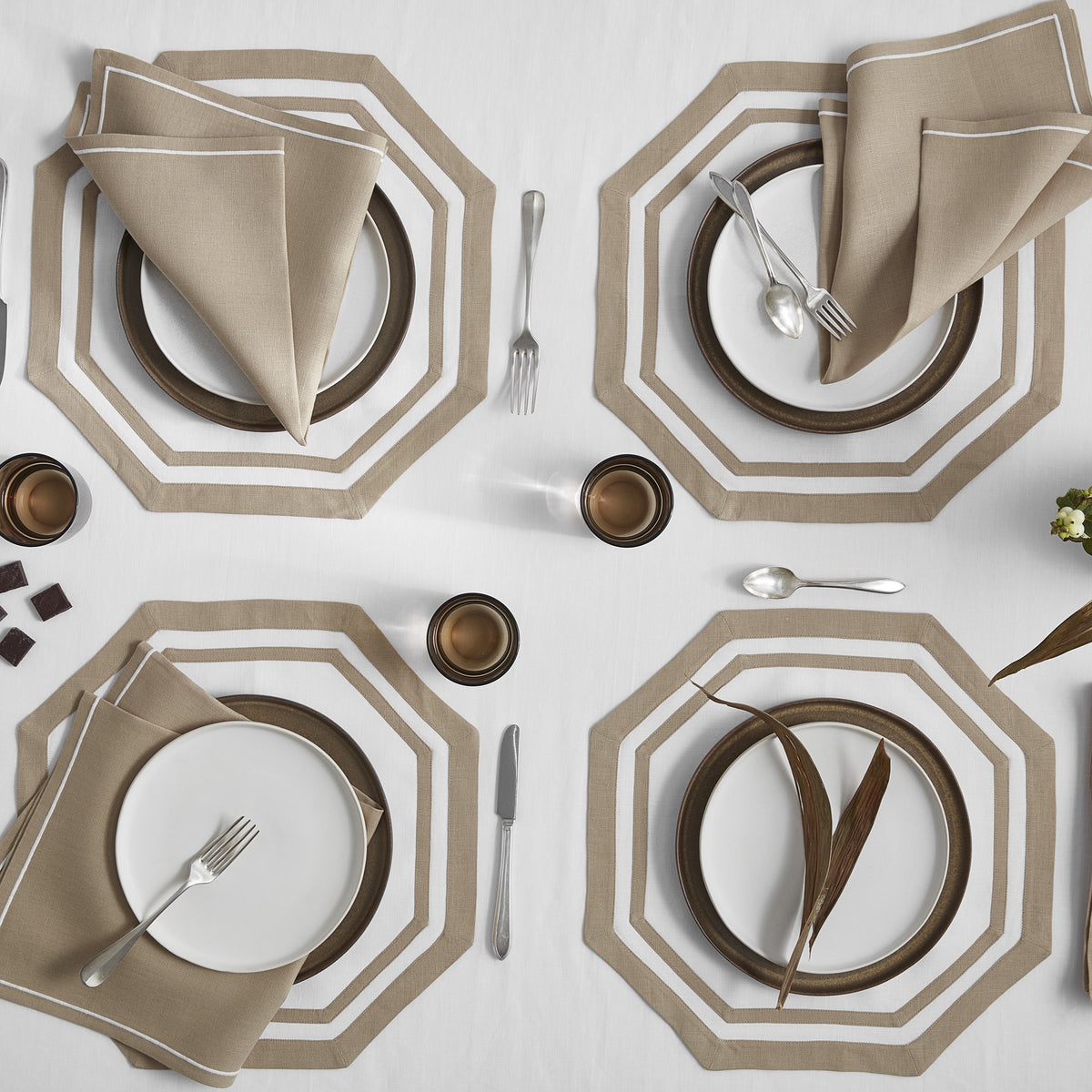 Matouk Double Border Placemats on a Table with Matouk Satin Stitch Napkins in Oat Color