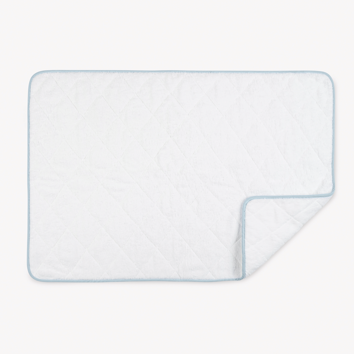 A white quilted blanket with light blue trim, reminiscent of the softness found in Matouk Giza Towels.