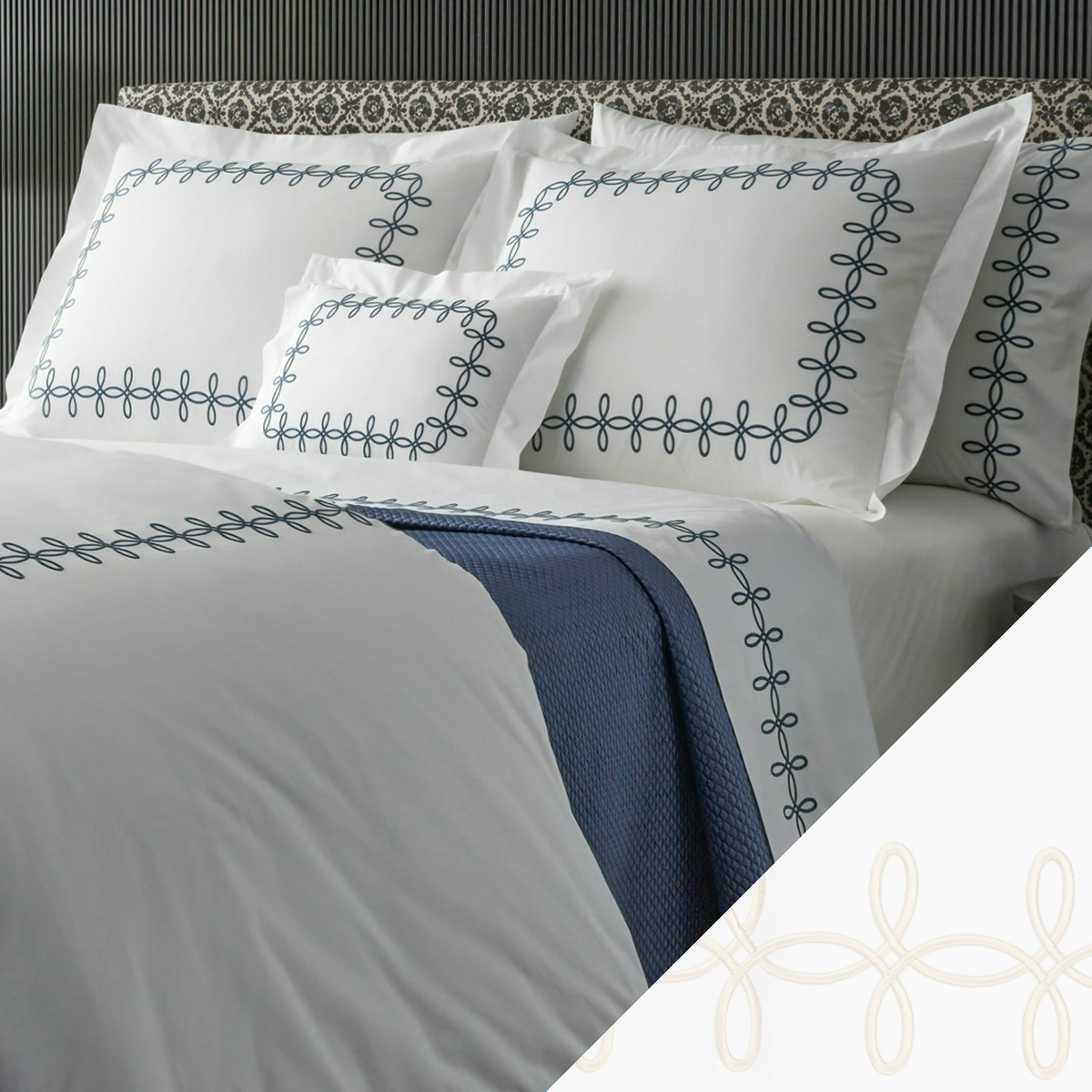 A neatly made bed with Matouk Gordian Knot Bedding, Baltic color embroidery, and a Cream swatch