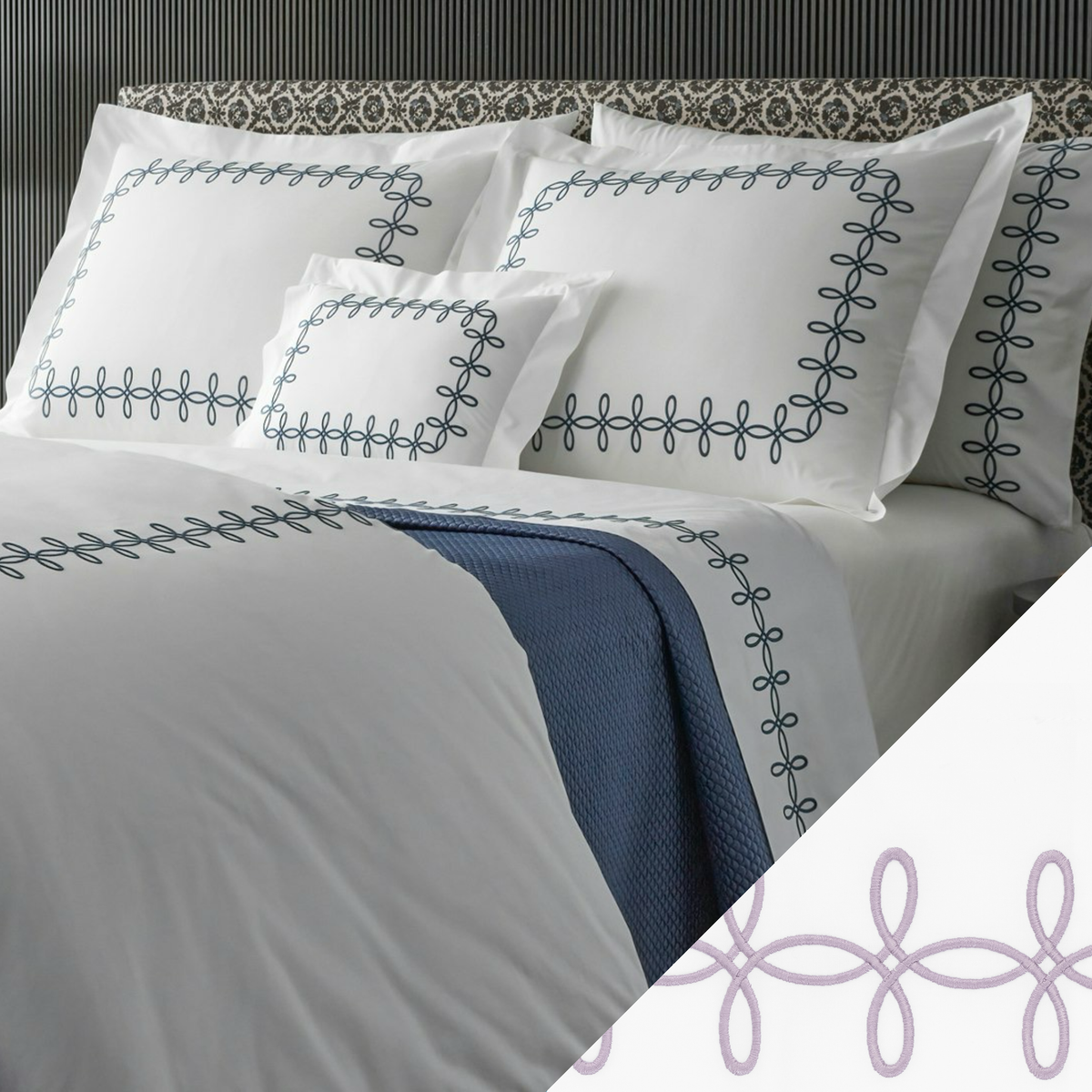 A neatly made bed with Matouk Gordian Knot Bedding, Baltic color embroidery, and a Lilac swatch