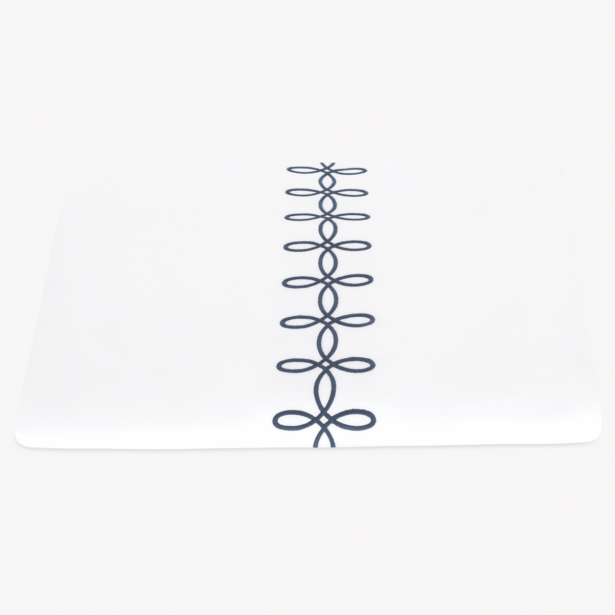 A folded Matouk Gordian Knot Duvet Cover with Baltic color embroidery