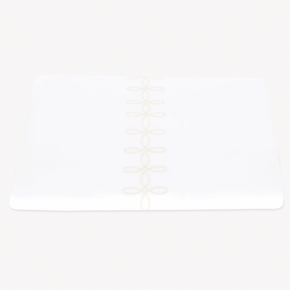 A folded Matouk Gordian Knot Duvet Cover with Cream color embroidery