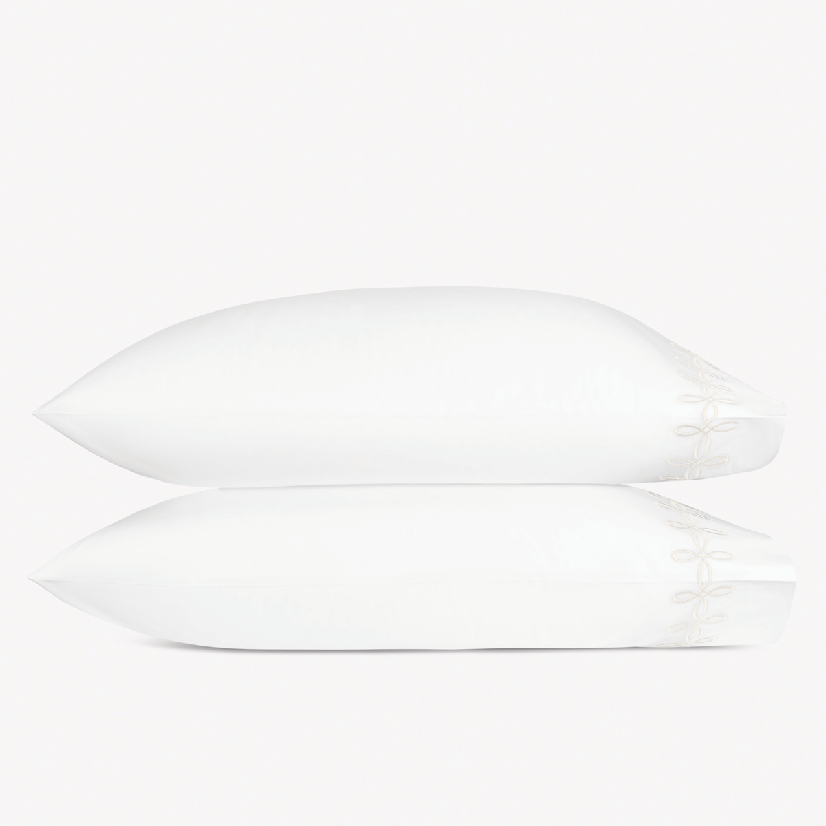 Two pillows with Cream color Matouk Gordian Knot pillowcases stacked