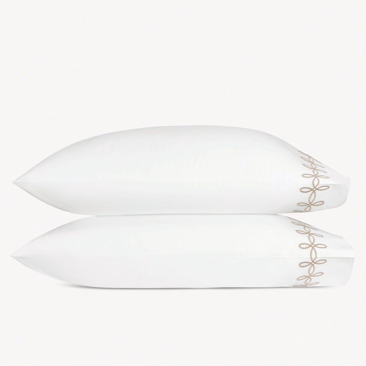Two pillows with Truffle color Matouk Gordian Knot pillowcases stacked