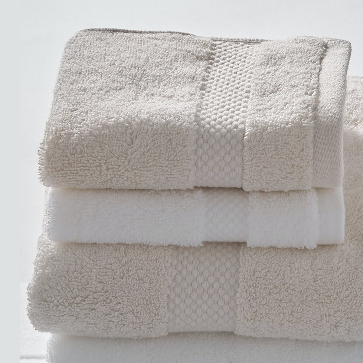 Stack of Matouk Guesthouse Bath Towels and Mat in Both Colors